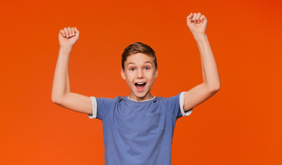 Joyful boy cheering, shouting with hands up