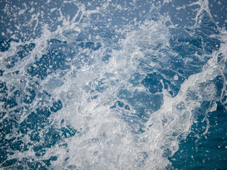 Splashes of water against the sea on a sunny summer day