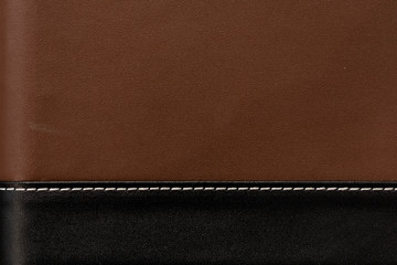 The combined natural leather of two colors: black and brown. Stitching of white color. A background for an inscription or  text