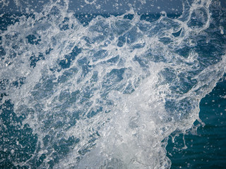 Fototapeta na wymiar Splashes of water against the sea on a sunny summer day