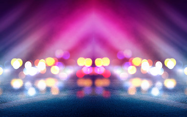 Dark empty stage, multicolored rays of neon searchlight, wet asphalt, smoke, night shooting, bokeh...