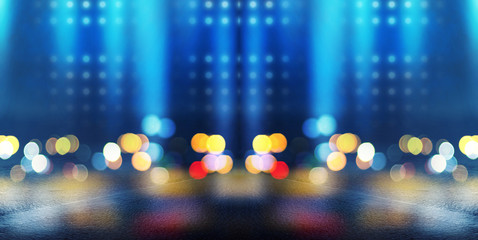 Dark empty stage, multicolored rays of neon searchlight, wet asphalt, smoke, night shooting, bokeh...