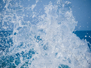 Splashes of water against the sea on a sunny summer day