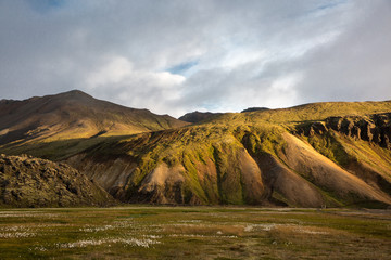 The sun's rays make their way through the clouds against the backdrop of mountains in Iceland