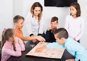 Children making move on pre-marked surface of board game