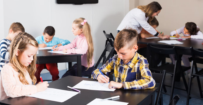 Little children with teacher drawing in classroom