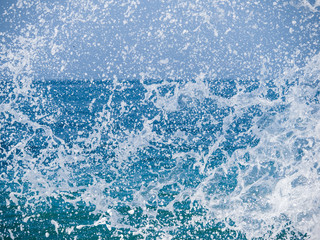 Splashes of water against the sea on a sunny summer day