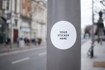 Sticker Mockup auf Straßenlaterne in einer Stadt mit großer Straße - obrazy, fototapety, plakaty