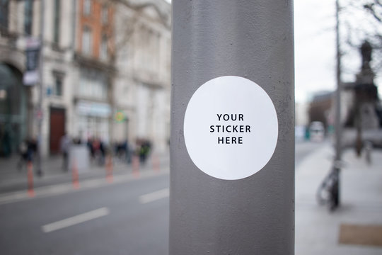 Sticker Mockup auf Straßenlaterne in einer Stadt mit großer Straße
