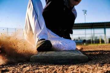 Baseball player slide into base, sports action close up.