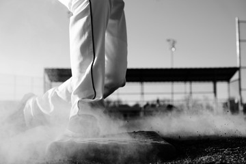 Baseball action from slide to base in black and white closeup.
