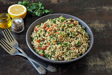 Arabic salad tabbouleh in a bowl. Middle Eastern cuisine. Healthy salad with bulgur, parsley and...