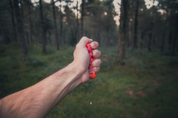  Man crushing a strawberries with his hand in nature