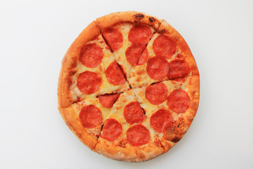Pepperoni pizza sliced round italian food close up top view isolated on empty white background. Fresh classic pepperoni pizza recipe of hot pizza with fresh pepperoni sausage and cheese ingredients