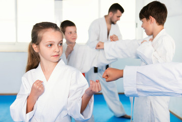 Pair of little girls practicing new karate moves during class