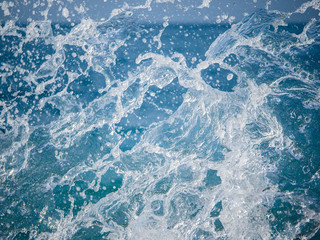 Splashes of water against the sea on a sunny summer day