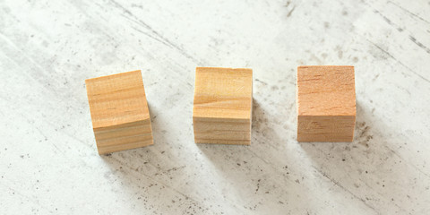 3 blank wood playing cubes on white board