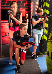 Obraz na płótnie Canvas Girls and boys playing laser tag