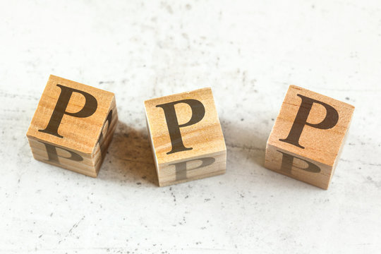 Three wooden cubes with letters PPP stands for Praise Picture Push on white board.