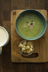 vegetarian green broccoli soup on wooden table. Vegan right lunch. Coffee and soup