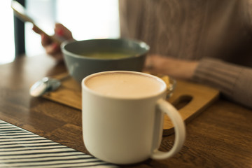 The girl with the phone is having lunch. The blogger is eating the right food. Veggie Green Broccoli Soup
