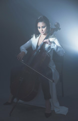 Beautiful woman in a white coat plays the cello © Антон Фрунзе