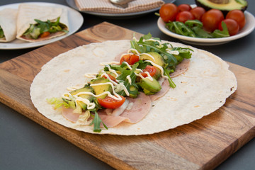 Fototapeta na wymiar Cooking healthy avocado and vegetables burrito, wraps, rolles. Healthy breakfast or snack. Avocado sandwich. Copy space.