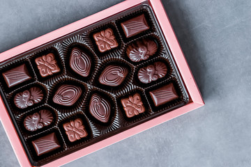 Box of chocolate candies on gray background.