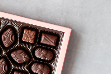 Box of chocolate candies on gray background.