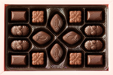 Box of chocolate candies on gray background.