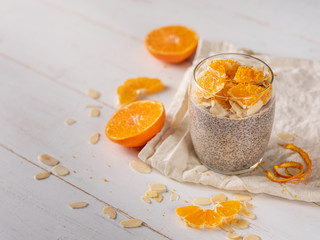 Chia seeds dessert with milk and citrus orange on white background.