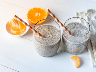 Cooking dessert ingredients with chia, milk and citrus orange on white background. Recipe steps by steps concept.