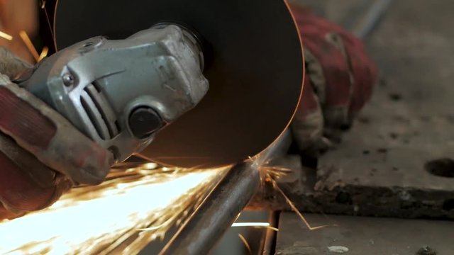 Close up picture of worker with cut grinder, men work with metal		