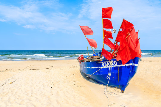 BAABE BEACH, RUEGEN ISLAND - JUN 1, 2018: Traditional blue color fishing boat on sandy beach in Baabe summer resort, Ruegen island, Baltic Sea, Germany.