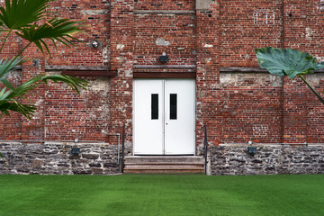 outdoor architecture with white door on a vibrant red brick wall