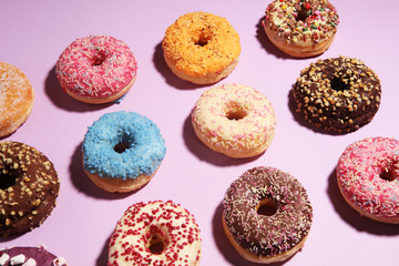 assorted donuts with chocolate frosted, pink glazed and sprinkles donuts.