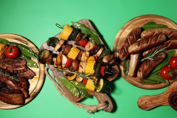Assorted delicious grilled meat and skewer with vegetable on rustic table