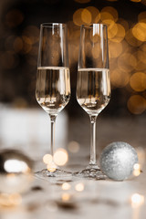 Champagne glasses stand on the table before a Christmas tree