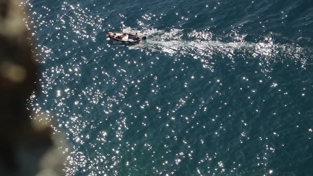 Bonassola, near Cinque Terre, Liguria. A boat in the blue sea seen from an overhanging rock. The promontory called "Salto della Lepre" offers a breathtaking view of the open sea of the Five Lands.