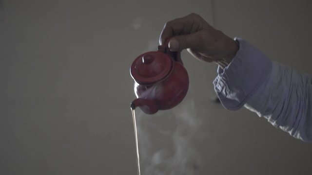 Close-up of teapot dropping hot tea.