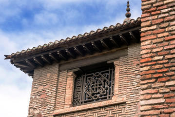 Malaga, Spain, February 2019. The fortress of Alcazaba is an Arab fortification on Mount Gibralfaro in the Spanish city of Malaga. Powerful brick walls. A window with a beautiful oriental pattern.
