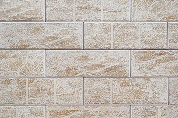 Wall of white brown rough ceramic tiles.