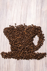 Roasted coffee beans like a cup on a wooden background