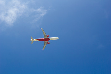Passenger plane flying in the blue sunny sky