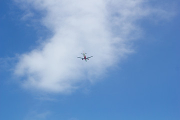 Fototapeta na wymiar Passenger plane flying in the blue sunny sky