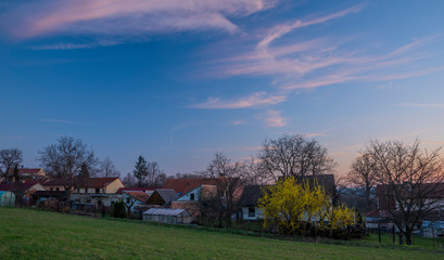 Sunset over Doubravice village with green fields in spring evening