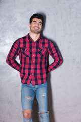 A happy young man in a red checkered shirt