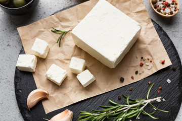 Block of feta cheese and spices on board