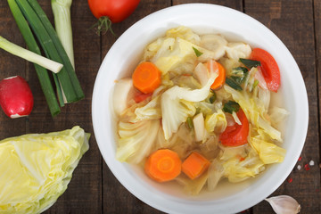 Springtime vegetarian soup surrounded with fresh vegatables. Healthy food. Top view.