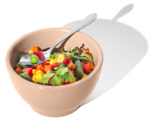 Dice cut vegetables in small bowl with spoon isolated on white background with hard long shadow